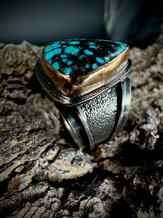 Silver ring with turquoise stone on a textured surface